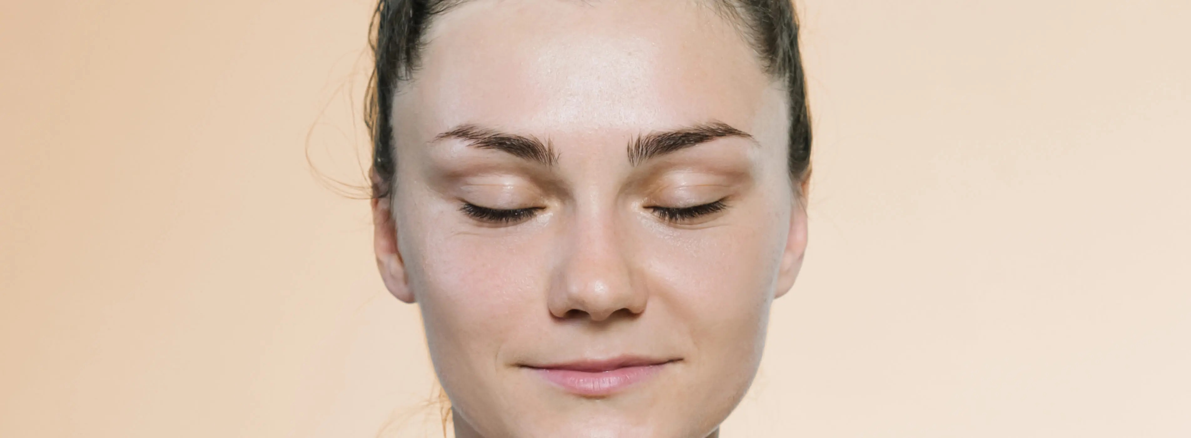 Junge Frau mit Dutt meditiert mit geschlossenen Augen